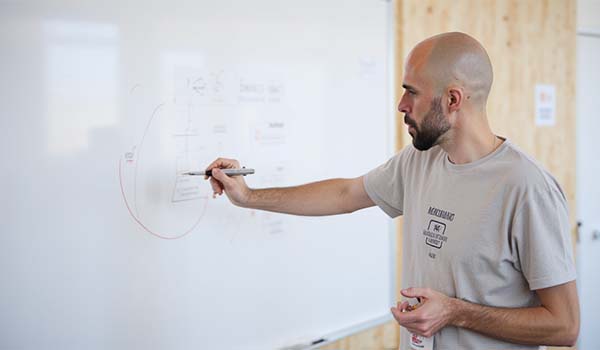 Álvaro Torres diseñando un plano en una pizarra para planificar un plugin a medida
