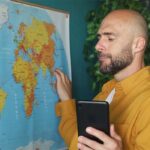 Álvaro Torres mirando un mapa del mundo en un portátil, pensando cómo llegar a nuevos países