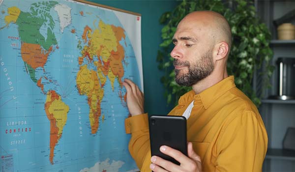 Álvaro Torres mirando un mapa del mundo en un portátil, pensando cómo llegar a nuevos países