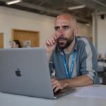 Álvaro Torres revisando el ROI del email marketing en su portátil, sorprendido por los resultados