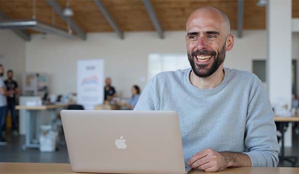 Álvaro Torres sonriendo al ver un informe con mejoras en tráfico y conversiones