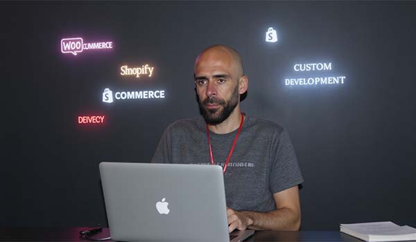 Álvaro Torres dudando entre WooCommerce, Shopify y un desarrollo a medida frente al portátil
