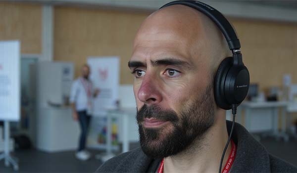 Álvaro Torres con auriculares, atendiendo una conversación que le pasa el chatbot