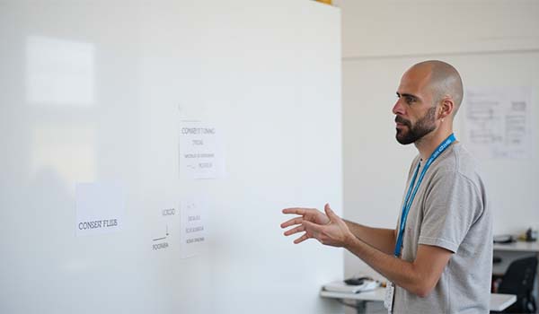 Álvaro Torres señalando un diagrama simple en una pizarra sobre cómo fluye el consentimiento en la web