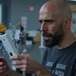 Álvaro Torres sosteniendo el móvil con muchas notificaciones, con gesto de saturación