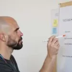 Álvaro Torres marcando una checklist de requisitos del proyecto en su portátil